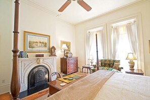 Une chambre d’hôtel avec une cheminée, un lit, une chaise et une table.