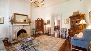 Un salon traditionnel avec une cheminée, un lustre et des meubles classiques.
