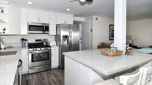 A modern kitchen with white cabinetry, stainless steel appliances, and a marble countertop. - 1005 E. Balboa A | Gorgeous Oceanfront w/ HUGE patio (Newport Beach)