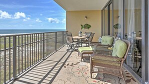 Ein Balkon mit Korbmöbeln, einem Tisch und einer Fischdekoration.