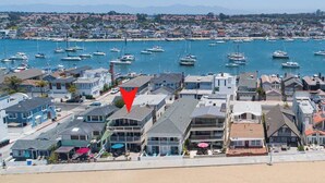 A coastal town with a marina filled with boats, residential buildings, and a beach.