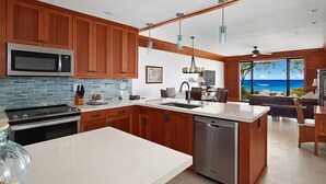 A modern kitchen with wooden cabinets, a stainless steel microwave, and a dishwasher.