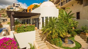 Ein Resort mit Pool, Gazebo und Springbrunnen, umgeben von üppiger Vegetation.