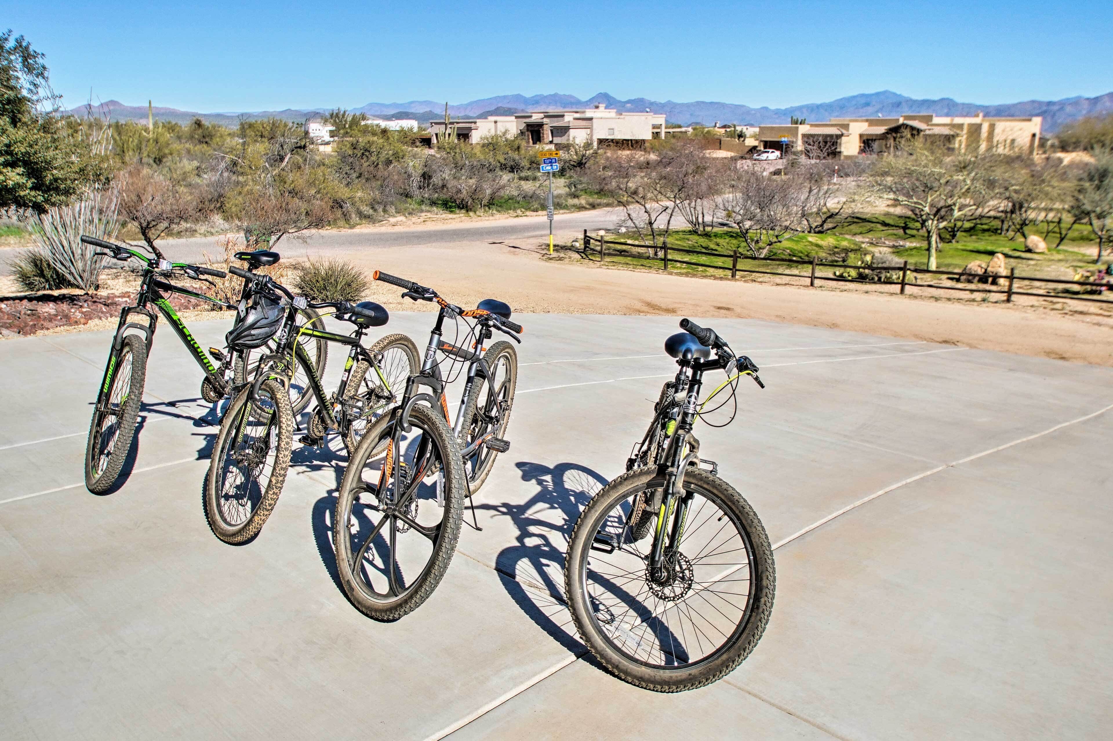 A paved area with three bicycles parked in a row.