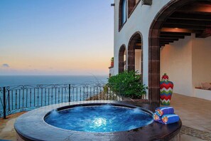 Ein Whirlpool auf einem Balkon mit Meerblick.