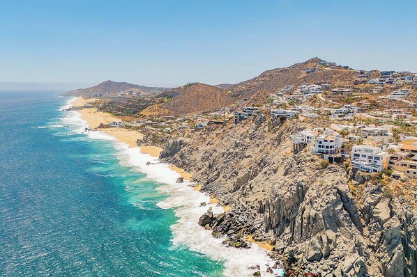 A coastal town with buildings on a hillside overlooking the sea.