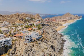 A coastal town with buildings on a rocky cliff overlooking the sea. - Oceanfront Luxury 12k SqFt Med-Style Villa w/ Pool, Hot Tub & Ocean Views Cabo (Cabo San Lucas)