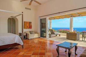 Ein Schlafzimmer mit Bett, Sofa und Meerblick.