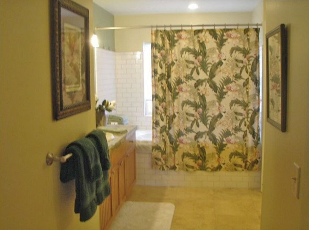 A bathroom with a shower curtain, a towel rack, and a sink.