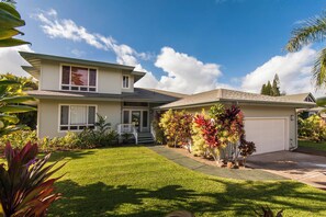 A two-story house with a front porch, a garage, and a well-maintained lawn.