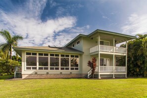 A two-story house with a large front porch and a balcony. - Modern AC Home w/ Golf Course & Mountain Views! (Princeville)