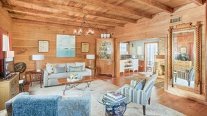 A cozy log cabin interior with a living room, dining area, and kitchen.