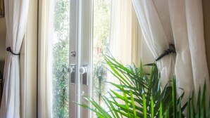 A door with a glass panel, white curtains, and a potted plant in the foreground. - Intimate Studio Hideaway Perfect for Couples by Lucky Savannah (Savannah)