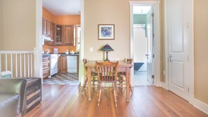 A dining area with a wooden table and chairs, a lamp, and a kitchen in the background. - Intimate Studio Hideaway Perfect for Couples by Lucky Savannah (Savannah)