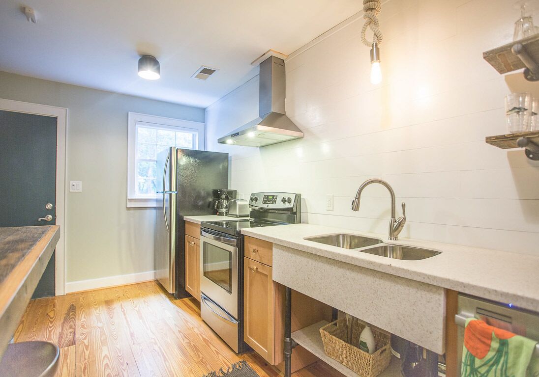 A modern kitchen with stainless steel appliances, wooden cabinets, and a double sink.