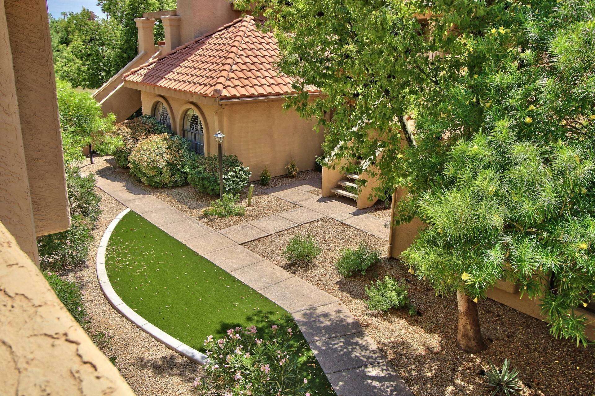 A house with a tiled roof, a paved driveway, and a well-maintained lawn.