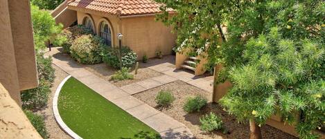 A house with a tiled roof, a paved driveway, and a well-maintained lawn.