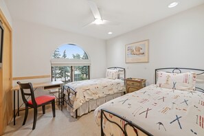 A bedroom with two beds, a desk, a chair, a window, and a ceiling fan. - Luxury Condo in Vail Village, Walk to Lifts, Tyro5 (Vail)