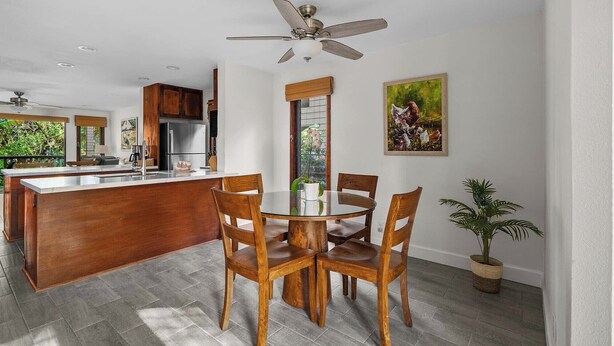 A modern kitchen with a central island, wooden chairs, and a ceiling fan. - Waikomo Stream Villas #420 By Parrish Kauai: updated and spacious unit, walk to (Koloa)