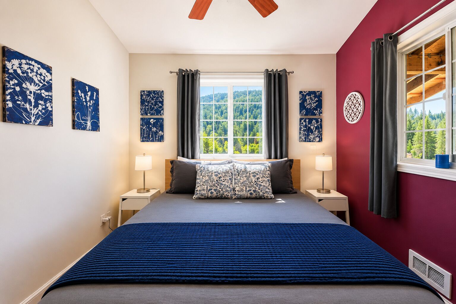 Ein Schlafzimmer mit einem großen Bett, zwei Nachttischen, einem Fenster mit Vorhängen und Wandbildern.