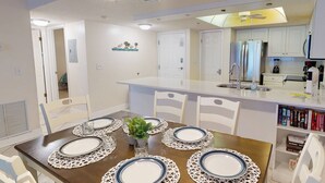 Una cocina moderna con armarios blancos, un refrigerador de acero inoxidable y una isla integrada con pileta.