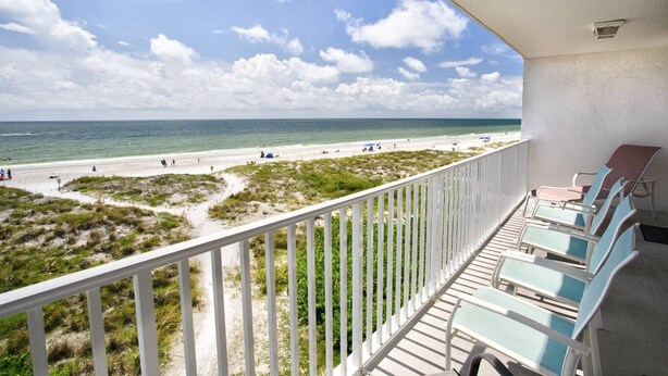 A balcony with a view of a beach, featuring a railing and several lounge chairs. - Incredible Beachfront View Private Balcony! 2 King Bedrooms, Pool & Hot Tub. Quiet and Relaxing Unit (Madeira Beach)
