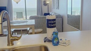 A hotel room with a balcony, a sink, a towel dispenser, and a bottle of dish soap. - Incredible Beachfront View Private Balcony! 2 King Bedrooms, Pool & Hot Tub. Quiet and Relaxing Unit (Madeira Beach)