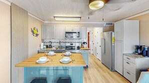 A modern kitchen with a central island, stainless steel appliances, and a wooden countertop. - Great oceanfront 1st floor unit with beach, fishing pier, and pool access (Isle of Palms)