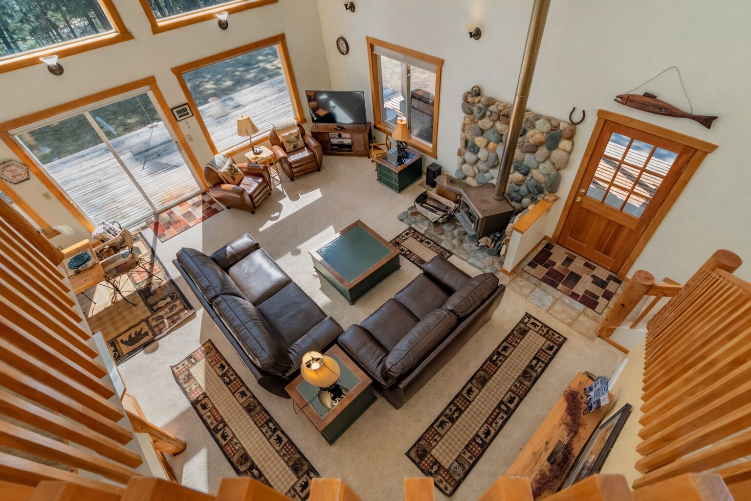 A spacious living room with a large sectional sofa, a fireplace, and a stone wall.