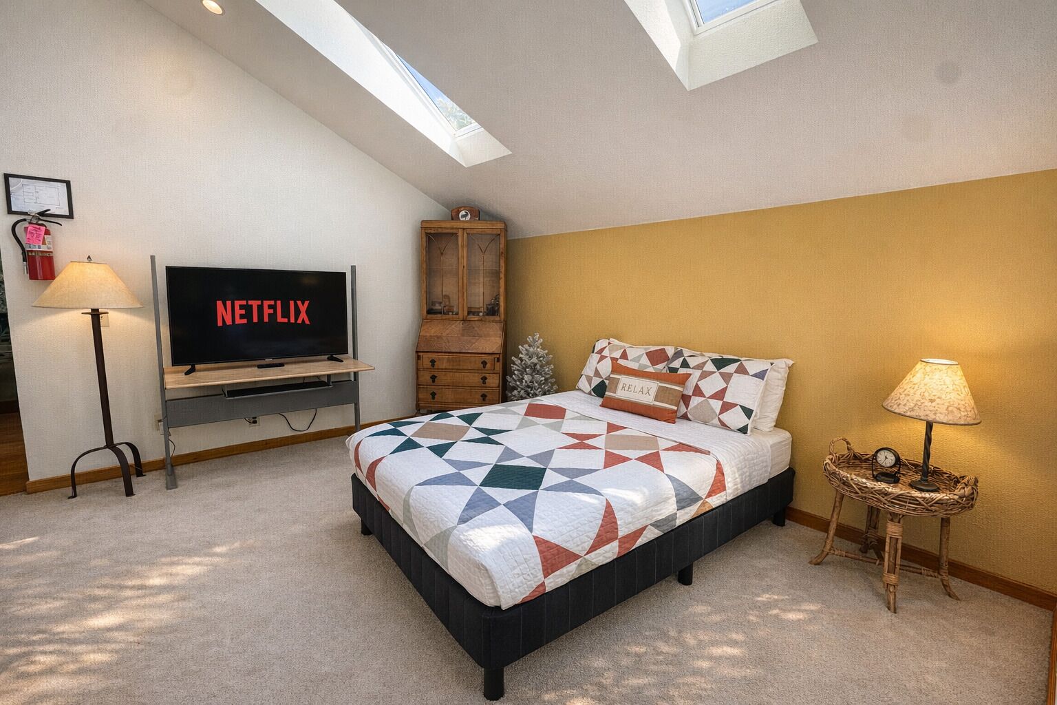 Una camera da letto con un letto, una televisione, una lampada, un armadio e una finestra.