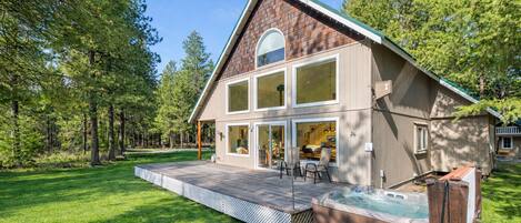 Une maison moderne à deux étages, dotée d’une grande terrasse, d’un jacuzzi et d’une pelouse bien entretenue.