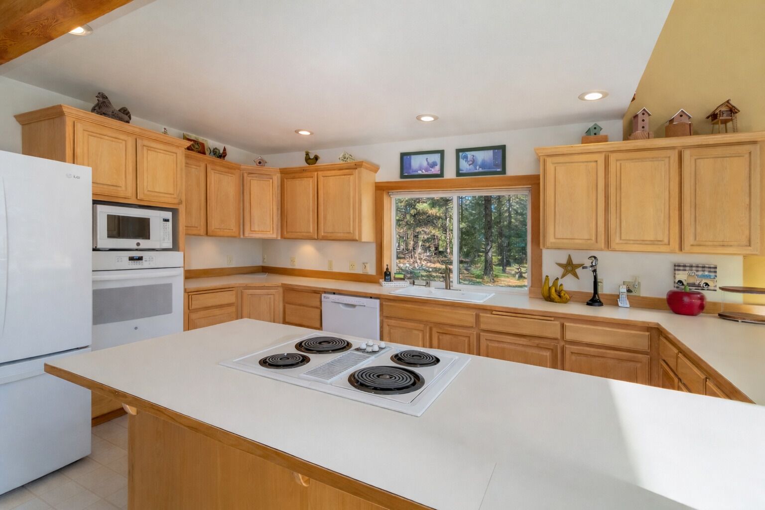 Una cocina moderna con armarios de madera, una isla central con estufa, microondas y lavavajillas.