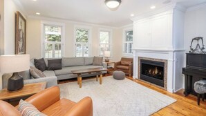 Un salon spacieux avec une cheminée, un canapé, une table basse et un manteau de cheminée.