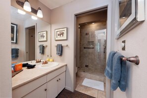 A bathroom with a sink, mirror, and shower. - Ski in/Ski Out Condo in Main Plaza - Corner Unit - Views of the Slopes (Durango)