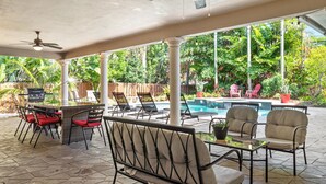 An outdoor patio with a pool, lounge chairs, and a table. - 5/3 Estate-Heated Pool-Hot tub-Beach-for 12 Guests (Hollywood)