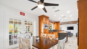 A modern kitchen with wooden cabinets, a built-in oven, and a large island. - 5/3 Estate-Heated Pool-Hot tub-Beach-for 12 Guests (Hollywood)