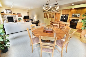 A modern kitchen with wooden cabinets, a dining table with chairs, and a fireplace. - Pool, Hot Tubs. 4 Suites! Walk to Main Street Dining, Shops. Near Rec Path (Frisco)