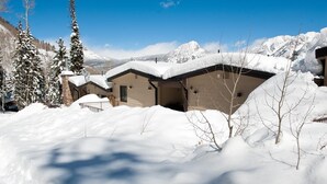 A snow-covered mountain lodge with multiple buildings, a clear blue sky, and snow-covered trees. - Sitzmark townhome at Purgatory - Awesome views - Steps to slopes (Durango)