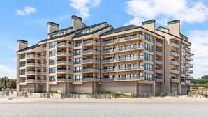 A multi-story hotel with balconies, a flat roof, and a sandy ground floor. - Outstanding condo in Wild Dunes with two oceanfront decks and pool access (Isle of Palms)