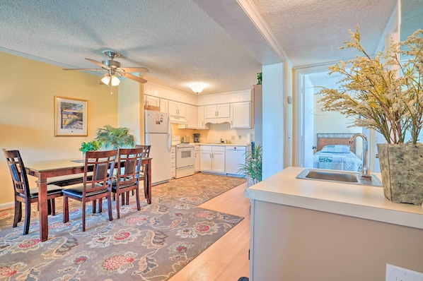 Cozy kitchen area with dining table for four, oven, and sink.