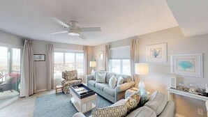 A spacious living room with a sofa, armchairs, a coffee table, and a ceiling fan. - Oceanfront 1st floor condo with direct beach access from private porch (Isle of Palms)