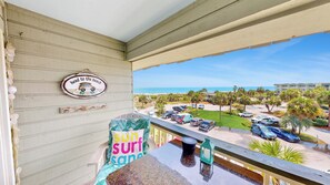 A balcony with a view of a beach, a parking lot, and a sign that says 'head to the beach.' - Beautifully renovated oceanfront condo with private balcony and amazing views (Isle of Palms)