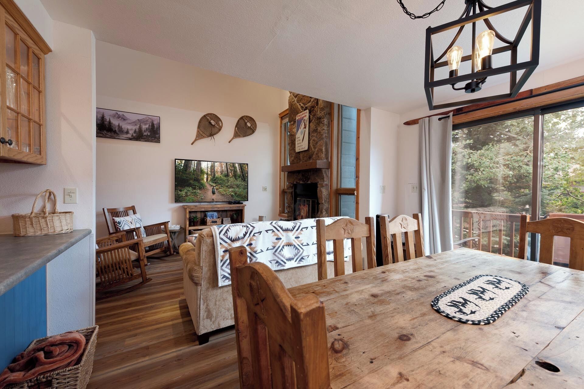 A cozy living area with a wooden dining table, chairs, a fireplace, and a television.