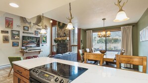 A kitchen with a large island, a dining area with a table and chairs, and a fireplace.