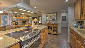 Una cocina amplia con encimeras de granito, horno empotrado y armarios de madera.