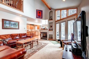 A spacious living room with a fireplace, a large TV, and a cozy seating area. - Village Townhome: Views, Location (Frisco)