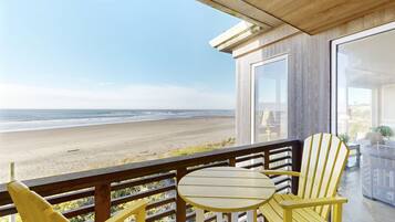 Enjoy the ocean view from this balcony with a glass door leading to the interior space.