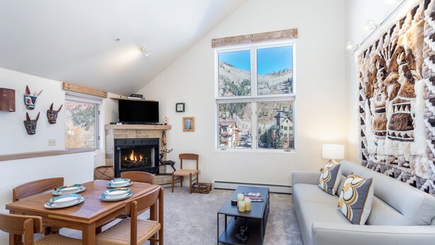 A living room with a fireplace, a dining area, and a sofa. - DOUBLE DIAMOND 3- Condo with Loft, Telluride near Chair 7 and Shuttle Route (Telluride)