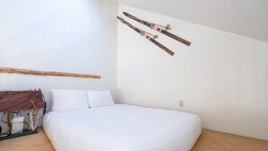 A bedroom with a large bed, a wooden headboard, and skis mounted on the wall. - DOUBLE DIAMOND 3- Condo with Loft, Telluride near Chair 7 and Shuttle Route (Telluride)