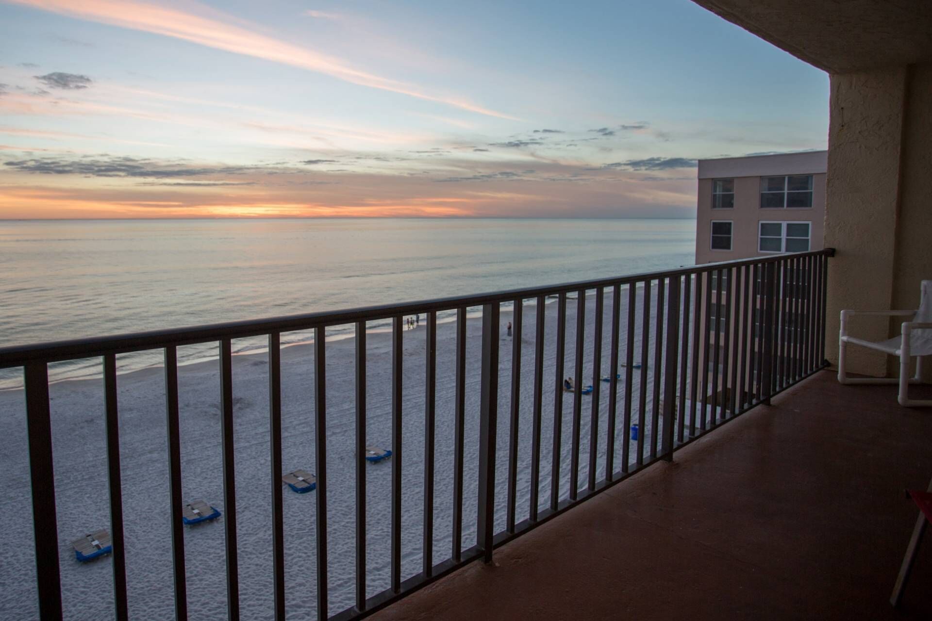 Ein Balkon mit Blick auf das Meer bei Sonnenuntergang.